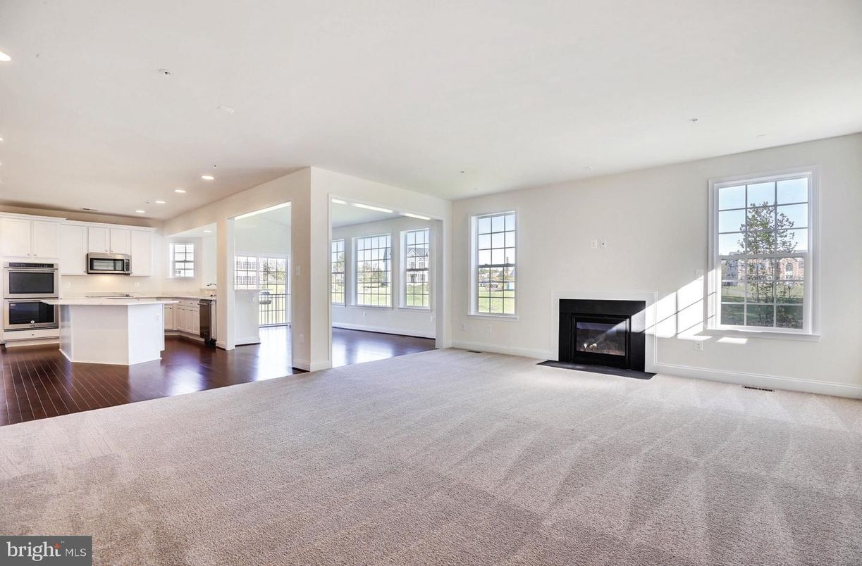 Empty room, Fireplace, Interior, Kitchen, Recessed Lighting, Stainless Steel Appliances, Wood Texture Flooring