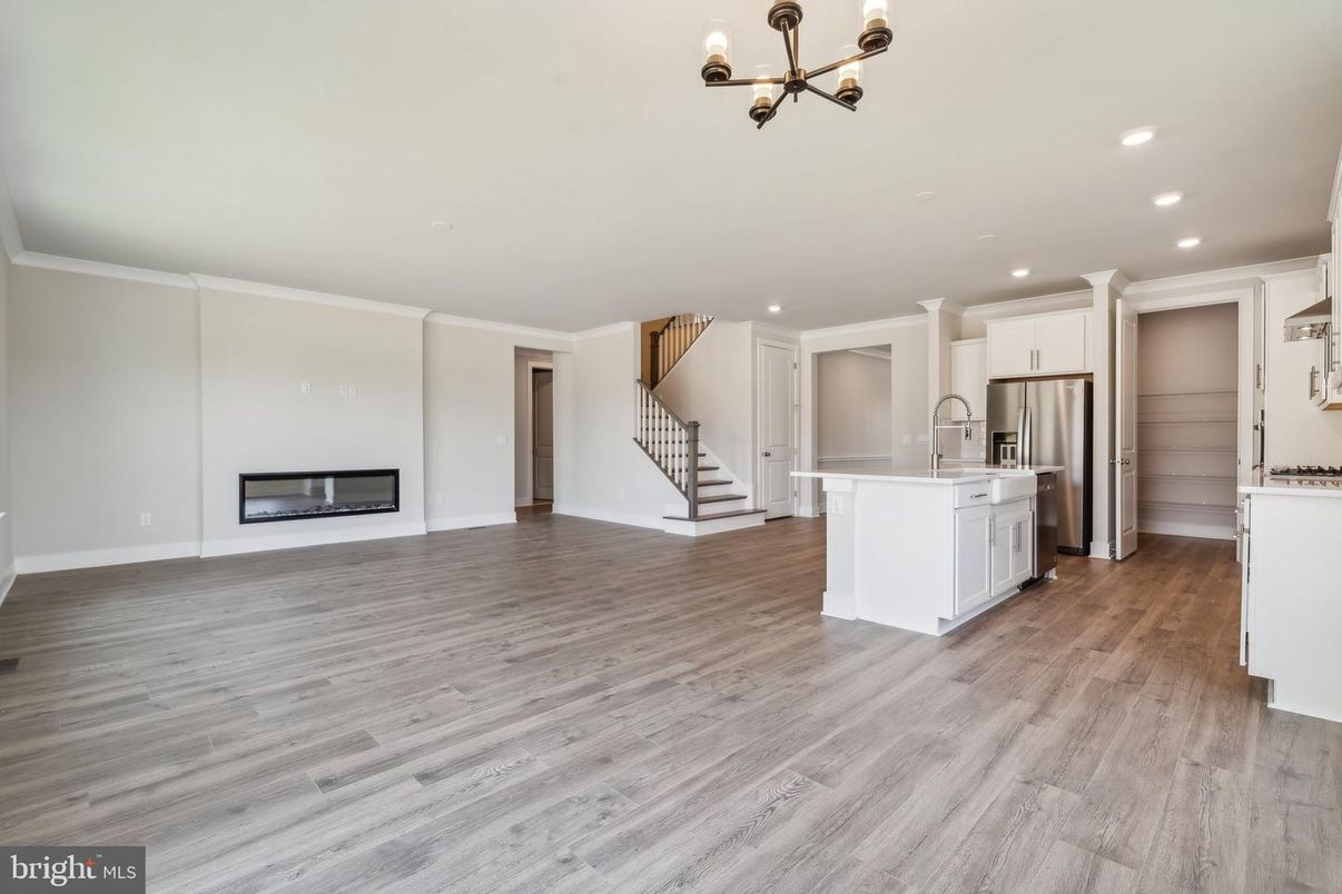 Empty room, Fireplace, Interior, Kitchen, Pendant Lights, Recessed Lighting, Stainless Steel Appliances, Wood Texture Flooring