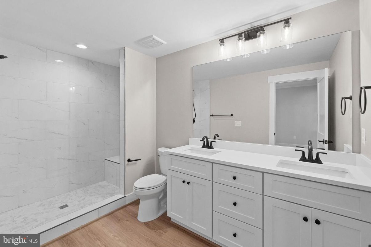Bathroom, Dual Sink Vanities, Glass Shower, Interior, Marble Walls, Recessed Lighting, Wood Texture Flooring