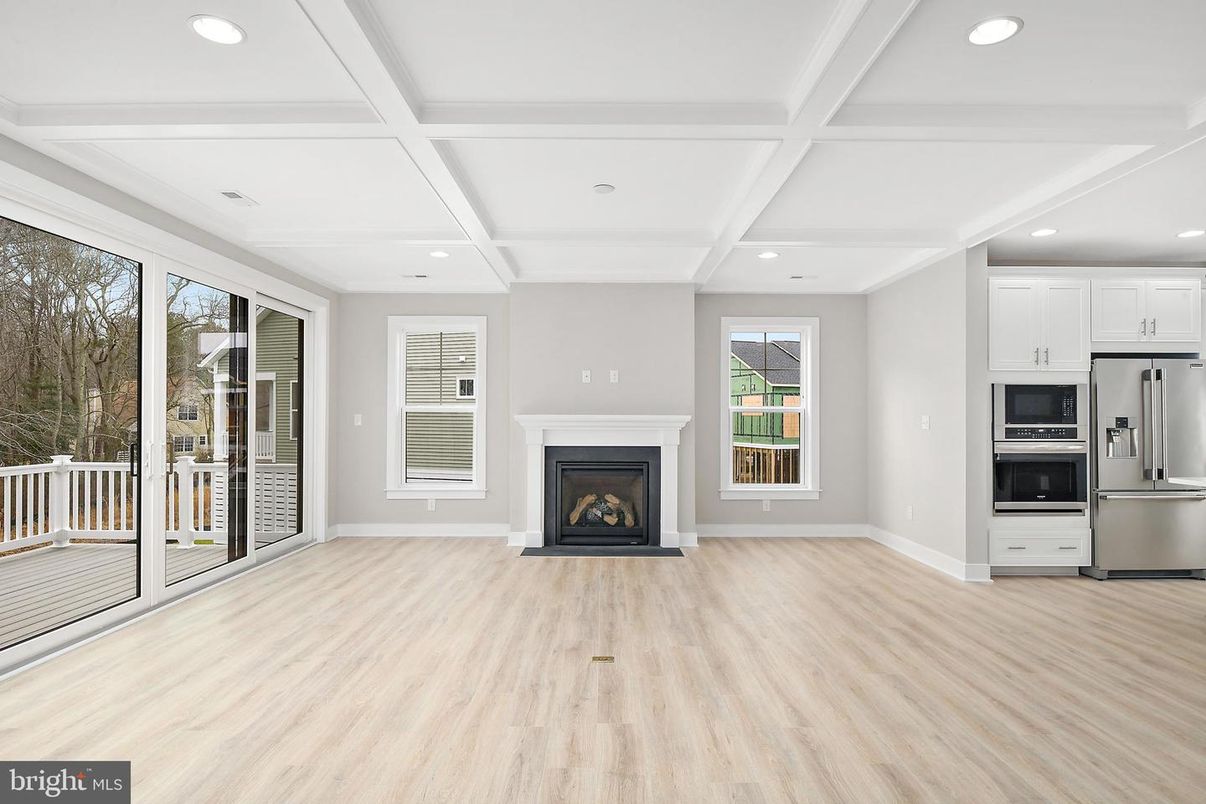 Empty room, Fireplace, Interior, Kitchen, Recessed Lighting, Stainless Steel Appliances, Wood Texture Flooring