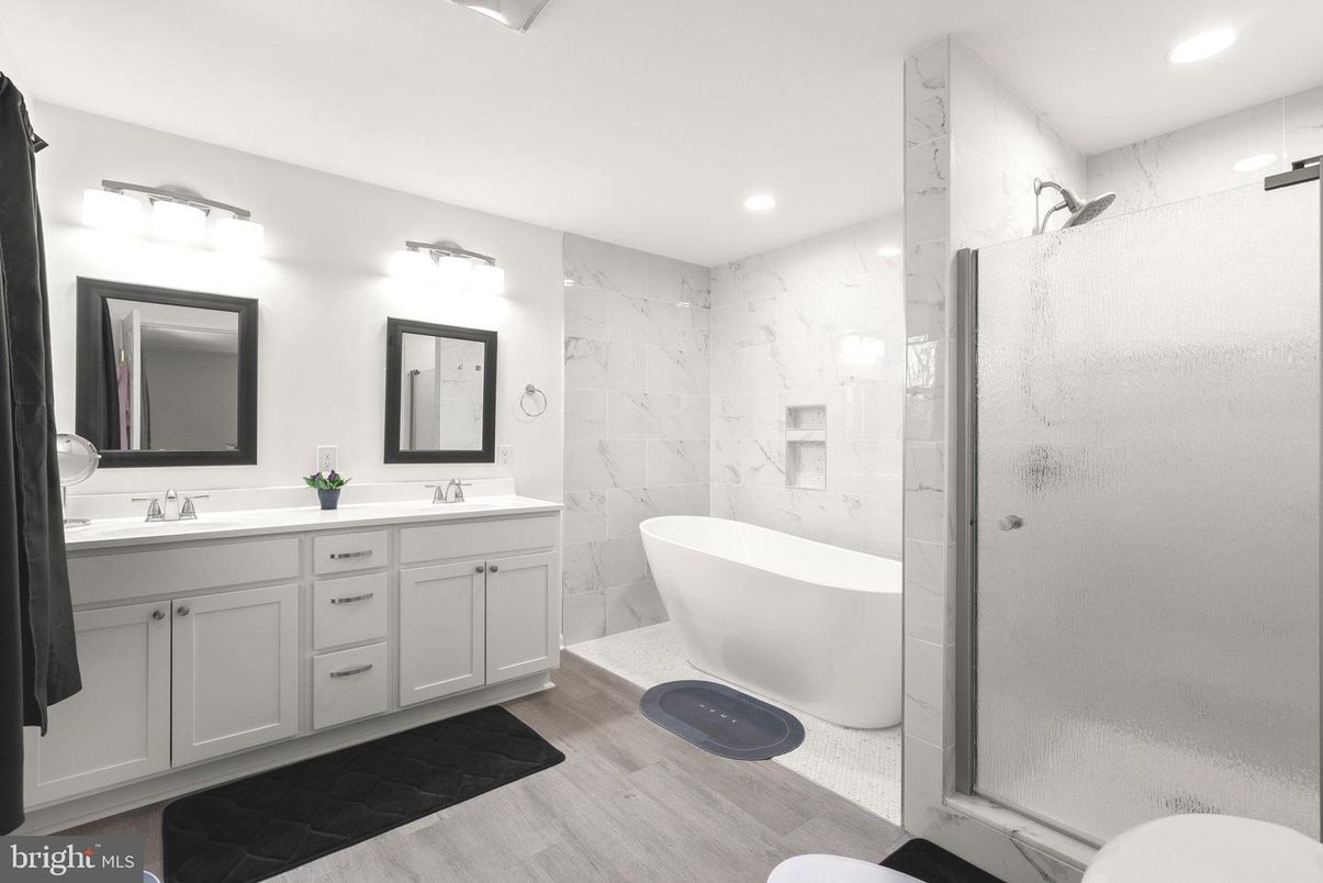 Bathroom, Dual Sink Vanities, Free Standing Baths, Glass Shower, Interior, Marble Walls, Recessed Lighting, Wood Texture Flooring