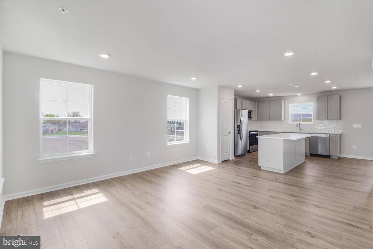 Empty room, Interior, Kitchen, Recessed Lighting, Stainless Steel Appliances, Wood Texture Flooring