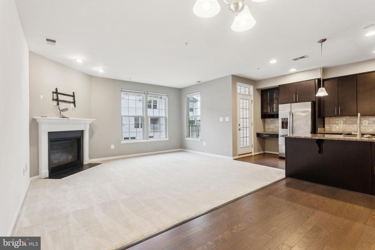 Empty room, Fireplace, Interior, Kitchen, Pendant Lights, Recessed Lighting, Stainless Steel Appliances, Wood Texture Flooring