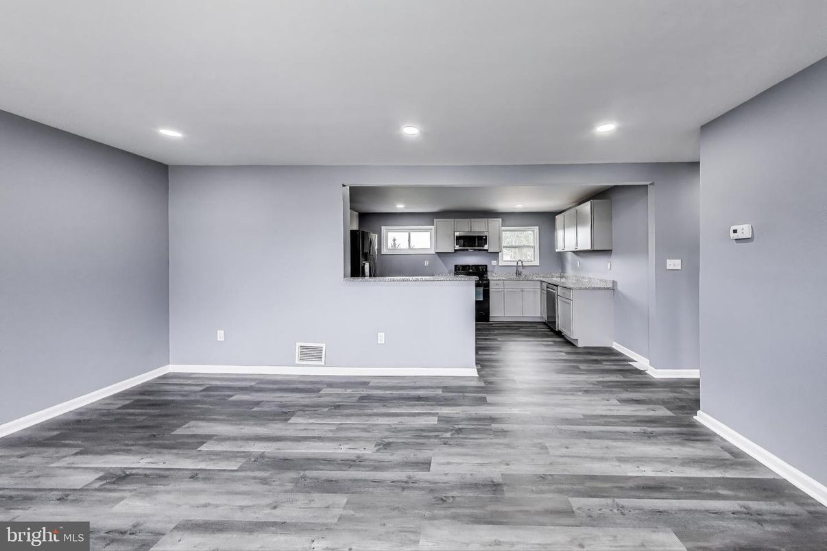 Empty room, Interior, Kitchen, Recessed Lighting, Stainless Steel Appliances, Wood Texture Flooring