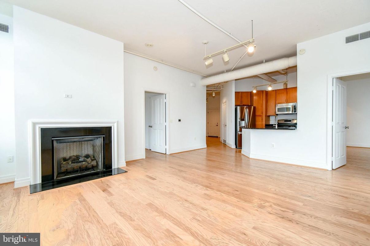 Empty room, Fireplace, Interior, Kitchen, Pendant Lights, Stainless Steel Appliances, Wood Texture Flooring