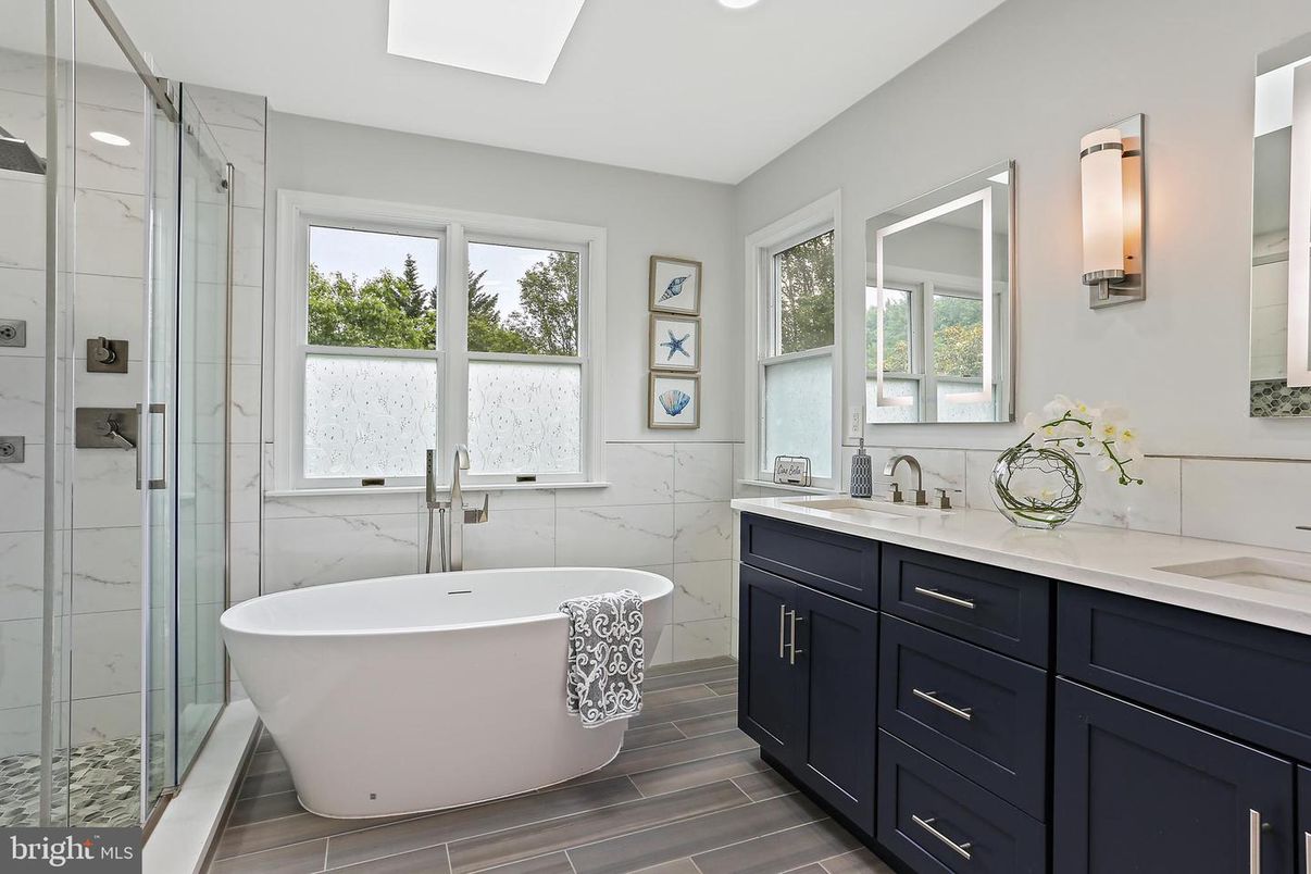 Bathroom, Dual Sink Vanities, Free Standing Baths, Glass Shower, Interior, Marble Walls, Recessed Lighting, Wood Texture Flooring