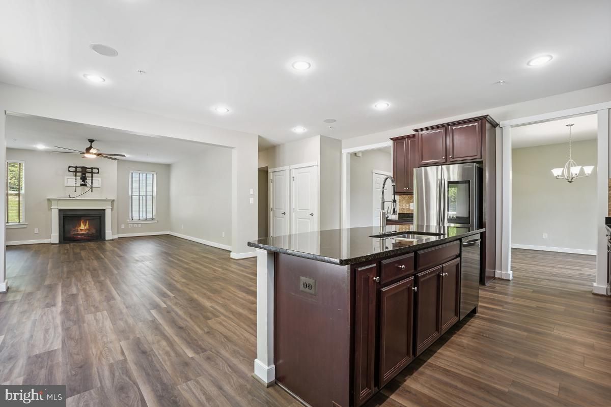 Chandelier, Empty room, Fireplace, Interior, Kitchen, Recessed Lighting, Stainless Steel Appliances, Wood Texture Flooring