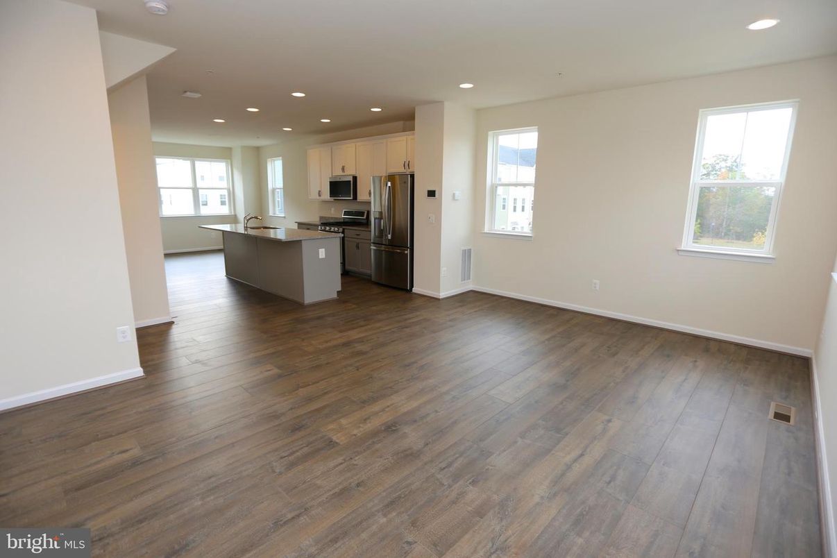 Empty room, Interior, Kitchen, Recessed Lighting, Stainless Steel Appliances, Wood Texture Flooring