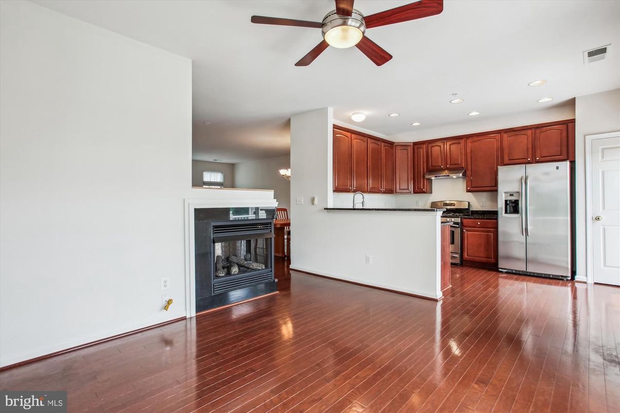 Empty room, Fireplace, Interior, Kitchen, Recessed Lighting, Stainless Steel Appliances, Wood Texture Flooring