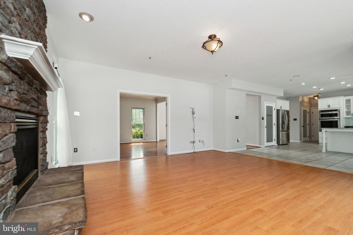 Empty room, Fireplace, Interior, Kitchen, Recessed Lighting, Stainless Steel Appliances, Wood Texture Flooring