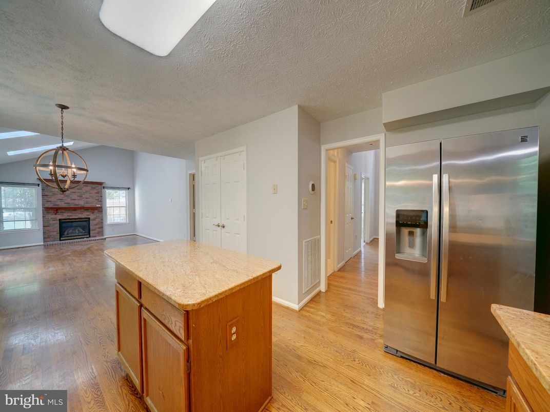 Chandelier, Fireplace, Interior, Kitchen, Pendant Lights, Stainless Steel Appliances, Wood Texture Flooring
