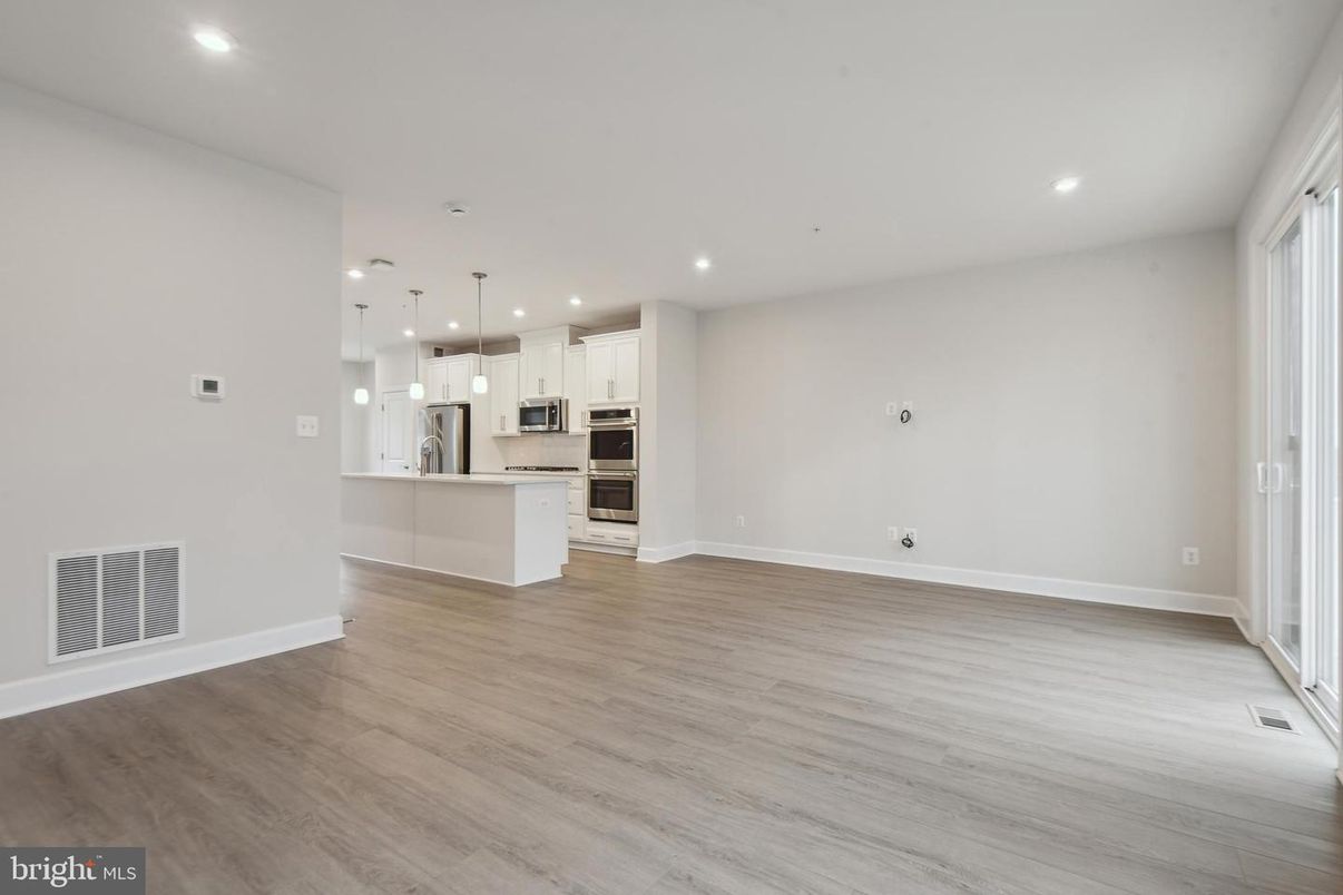 Empty room, Interior, Kitchen, Pendant Lights, Recessed Lighting, Stainless Steel Appliances, Wood Texture Flooring