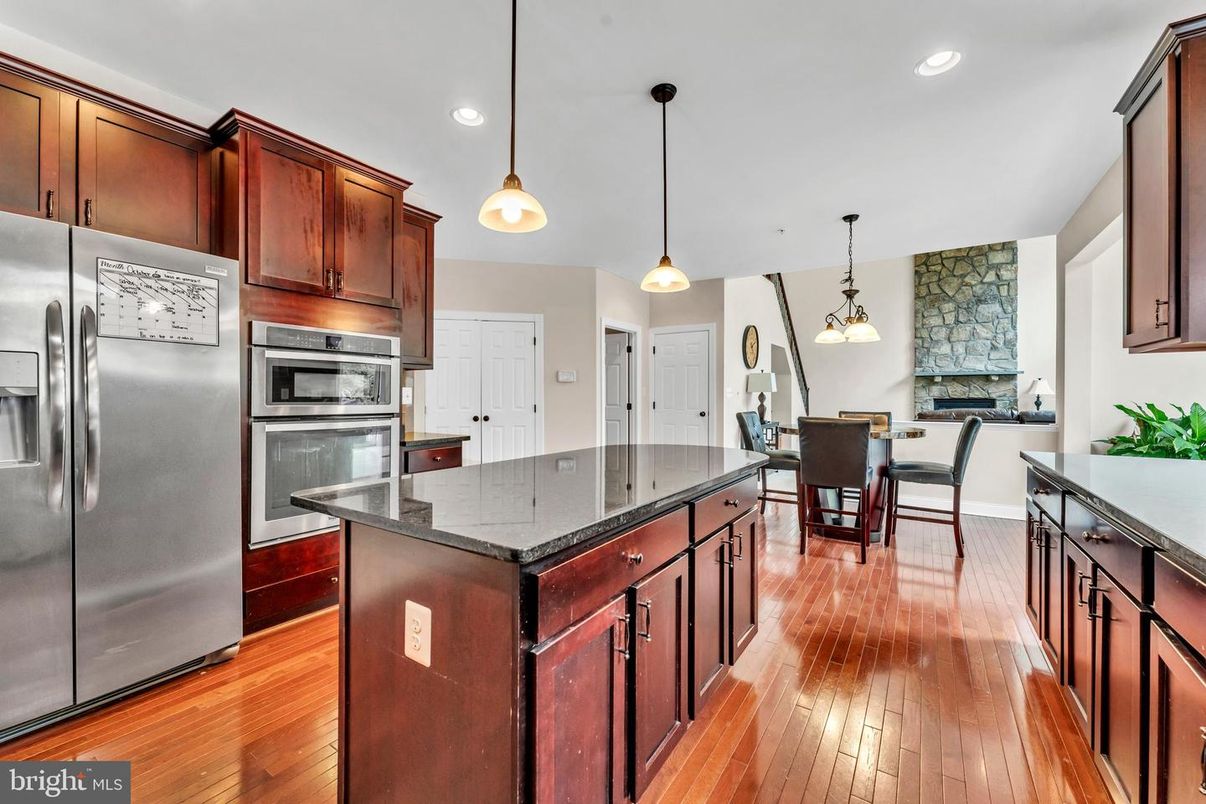 Dining room, Fireplace, Interior, Kitchen, Pendant Lights, Recessed Lighting, Stainless Steel Appliances, Stone Walls, Wood Texture Flooring