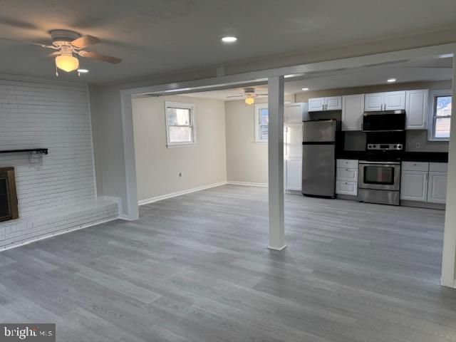 Empty room, Fireplace, Interior, Kitchen, Recessed Lighting, Stainless Steel Appliances, Wood Texture Flooring