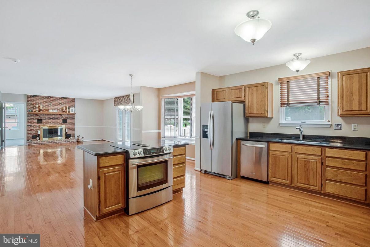 Fireplace, Interior, Kitchen, Pendant Lights, Stainless Steel Appliances, Stone Walls, Wood Texture Flooring