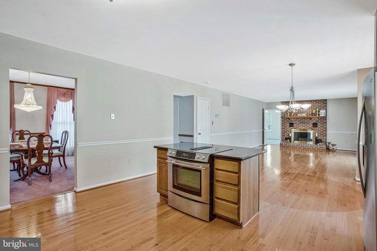 Chandelier, Dining room, Fireplace, Interior, Kitchen, Stainless Steel Appliances, Stone Walls, Wood Texture Flooring