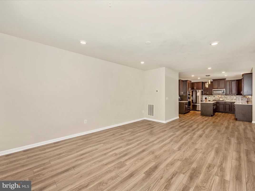 Empty room, Interior, Kitchen, Recessed Lighting, Stainless Steel Appliances, Wood Texture Flooring