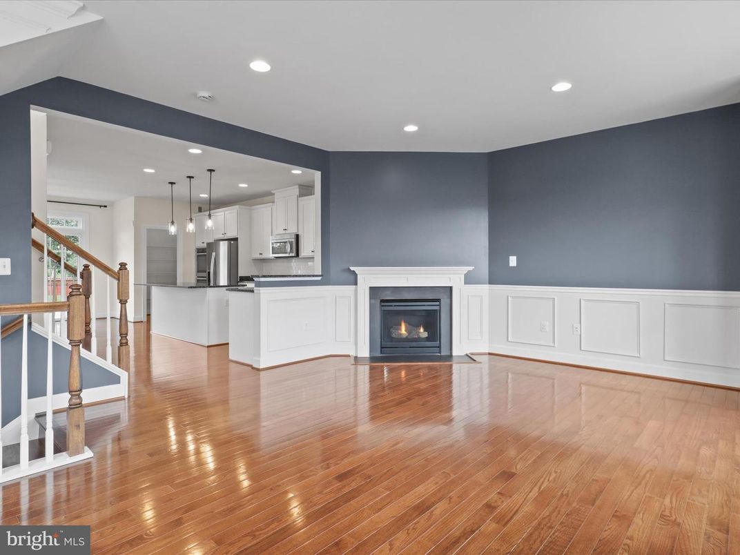 Empty room, Fireplace, Interior, Kitchen, Pendant Lights, Recessed Lighting, Stainless Steel Appliances, Wood Texture Flooring