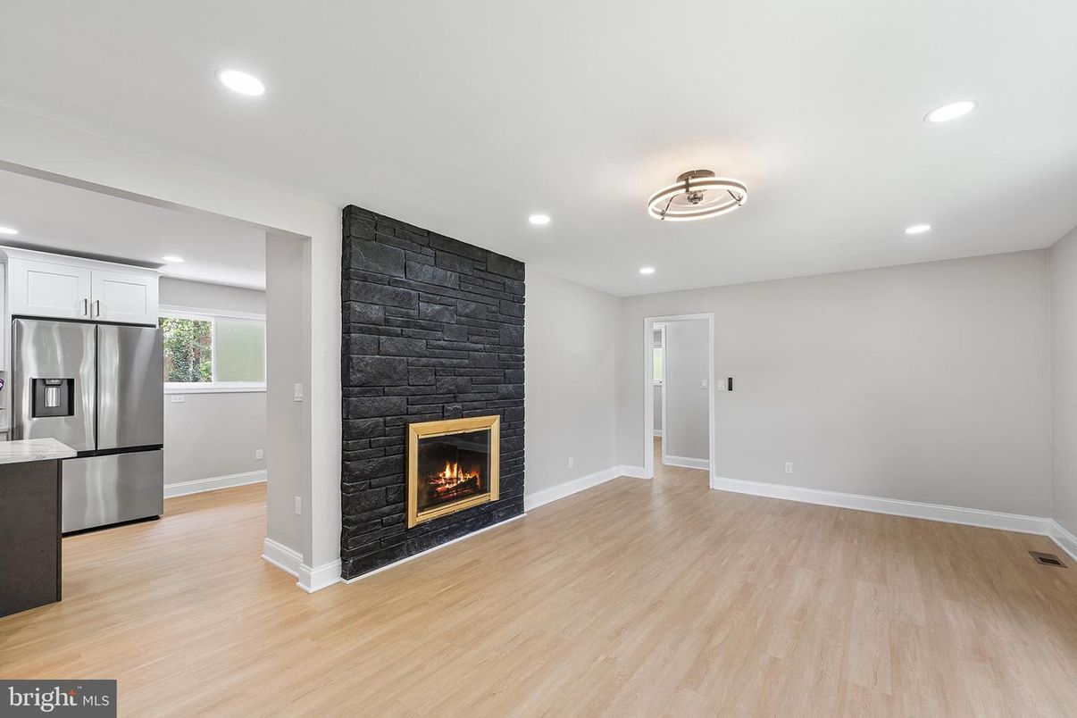 Empty room, Fireplace, Interior, Kitchen, Recessed Lighting, Stainless Steel Appliances, Wood Texture Flooring