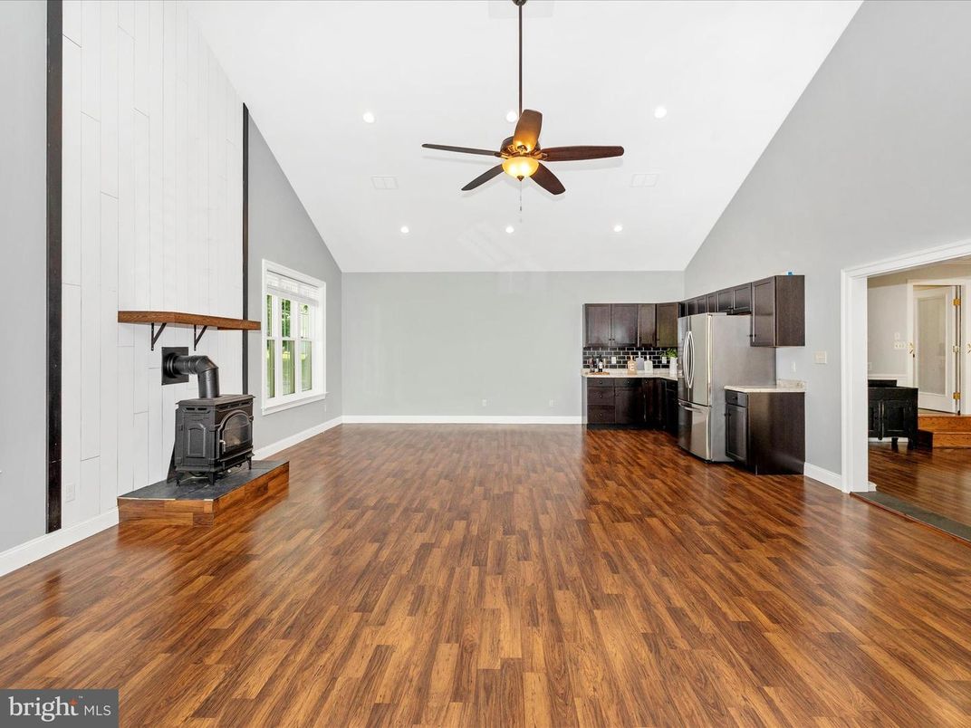 Empty room, Fireplace, Interior, Kitchen, Recessed Lighting, Stainless Steel Appliances, Wood Texture Flooring