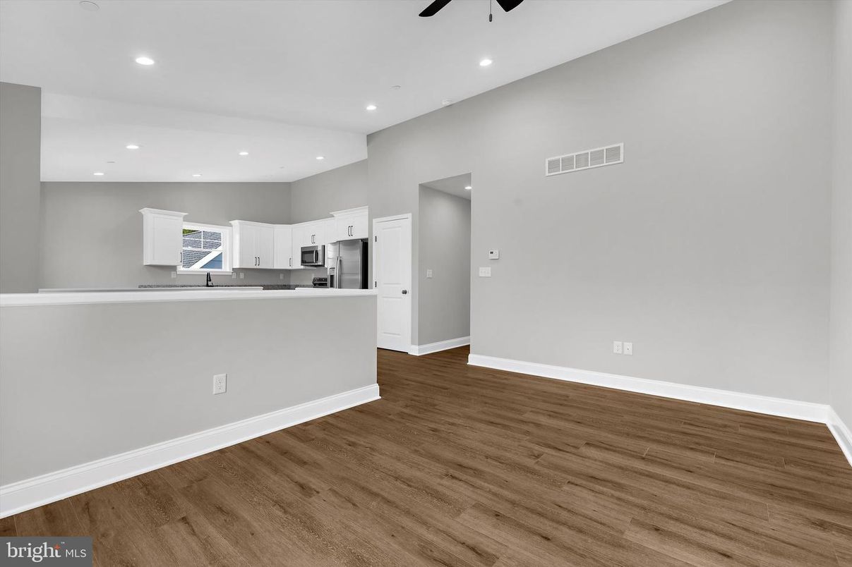 Empty room, Interior, Kitchen, Recessed Lighting, Stainless Steel Appliances, Wood Texture Flooring