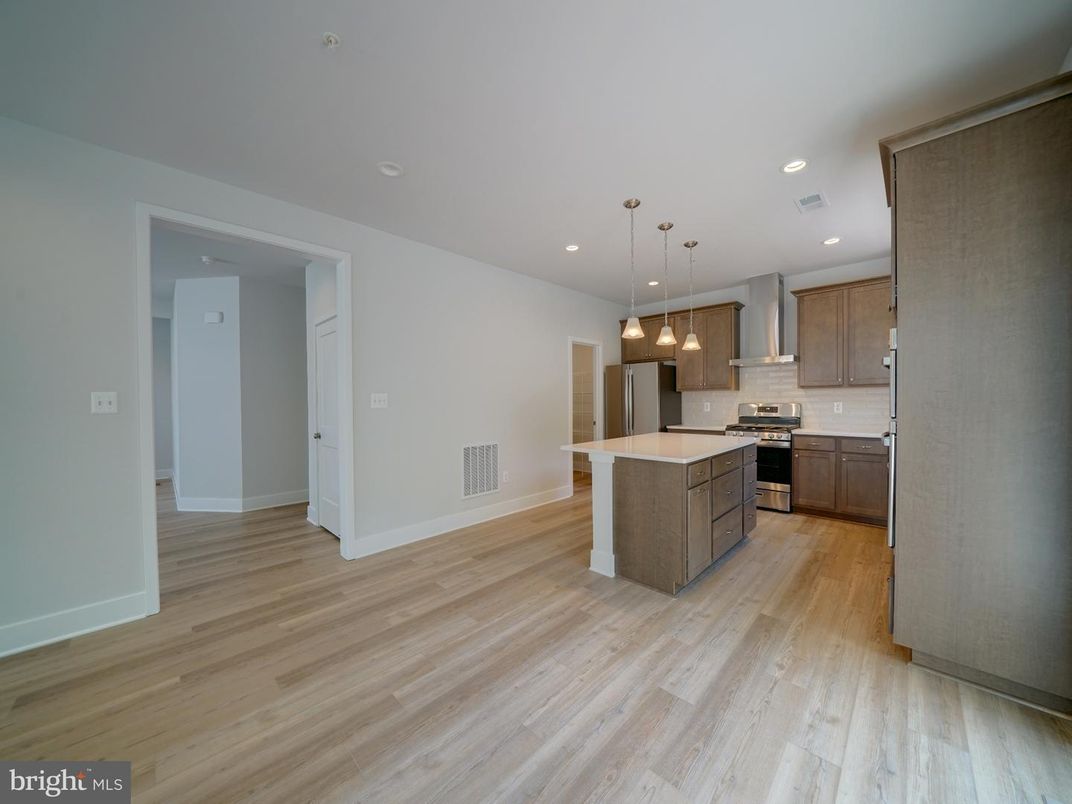 Empty room, Interior, Kitchen, Pendant Lights, Recessed Lighting, Stainless Steel Appliances, Wood Texture Flooring