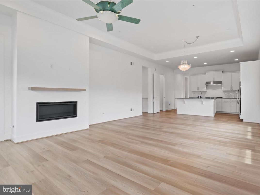 Chandelier, Empty room, Fireplace, Interior, Kitchen, Pendant Lights, Recessed Lighting, Stainless Steel Appliances, Wood Texture Flooring