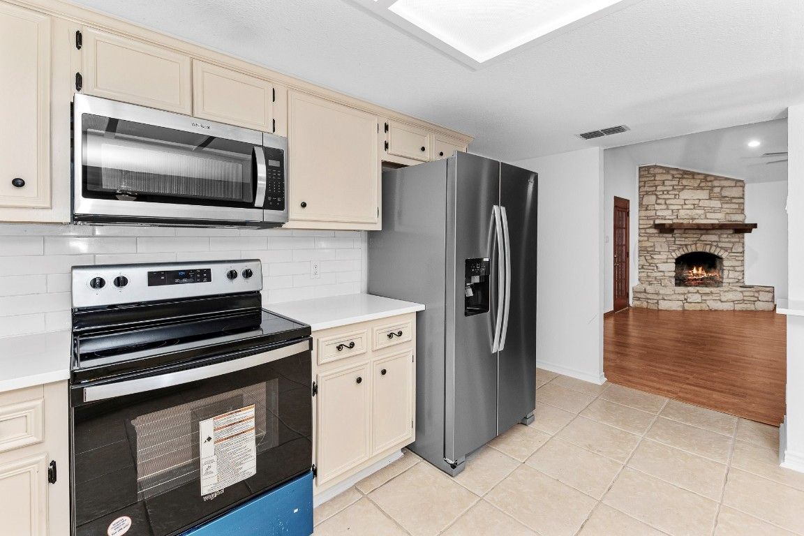 Fireplace, Interior, Kitchen, Recessed Lighting, Stainless Steel Appliances, Stone Walls, Wood Texture Flooring