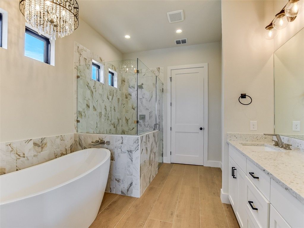 Bathroom, Chandelier, Dual Sink Vanities, Free Standing Baths, Glass Shower, Interior, Marble Walls, Recessed Lighting, Wood Texture Flooring
