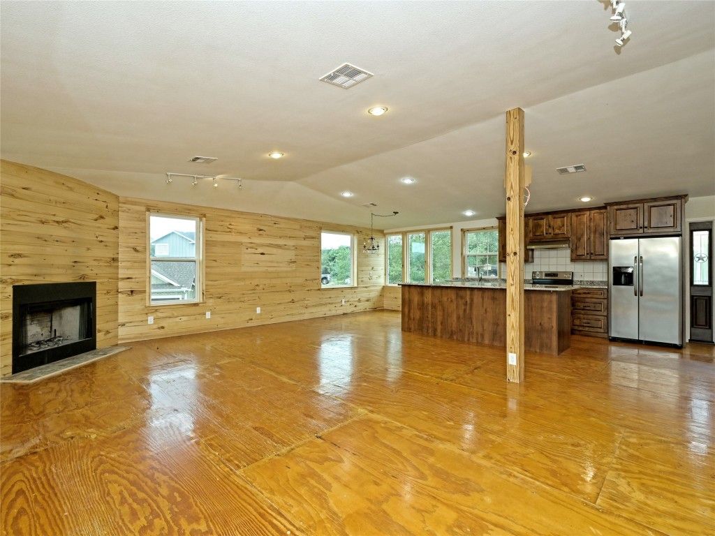 Empty room, Fireplace, Interior, Kitchen, Pendant Lights, Recessed Lighting, Stainless Steel Appliances, Wood Texture Flooring, Wooden Walls