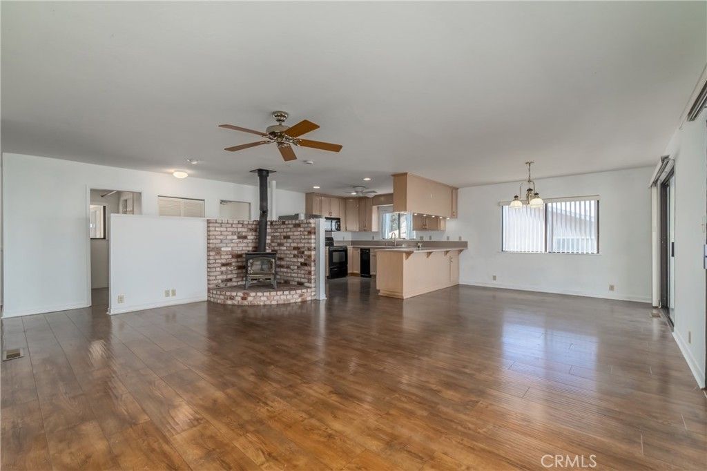 Empty room, Fireplace, Interior, Kitchen, Recessed Lighting, Stainless Steel Appliances, Stone Walls, Wood Texture Flooring