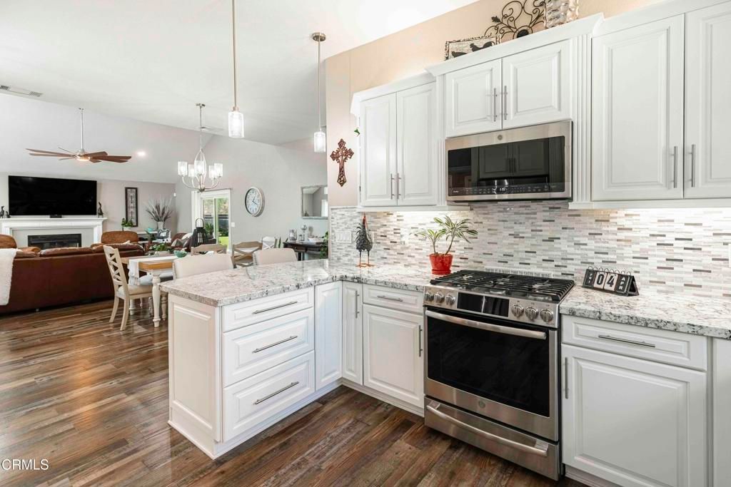 Chandelier, Dining room, Fireplace, Interior, Kitchen, Living room, Pendant Lights, Stainless Steel Appliances, Wood Texture Flooring