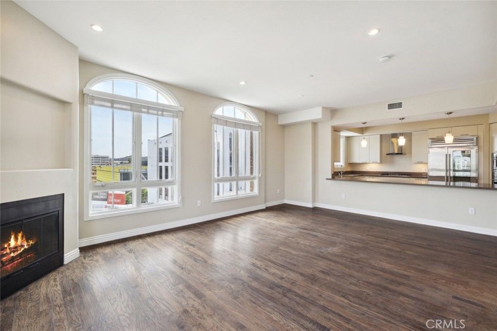 Empty room, Fireplace, Interior, Kitchen, Pendant Lights, Recessed Lighting, Stainless Steel Appliances, Wood Texture Flooring