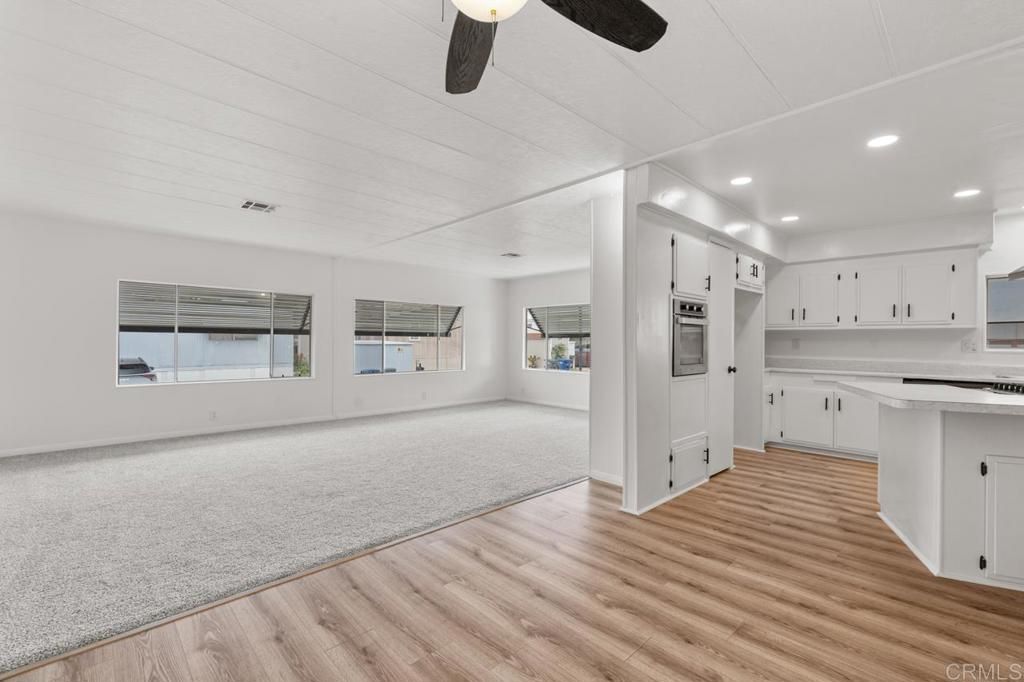 Empty room, Interior, Kitchen, Recessed Lighting, Stainless Steel Appliances, Wood Texture Flooring