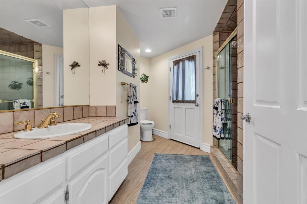 Bathroom, Dual Sink Vanities, Glass Shower, Interior, Recessed Lighting, Tile Countertops, Wood Texture Flooring