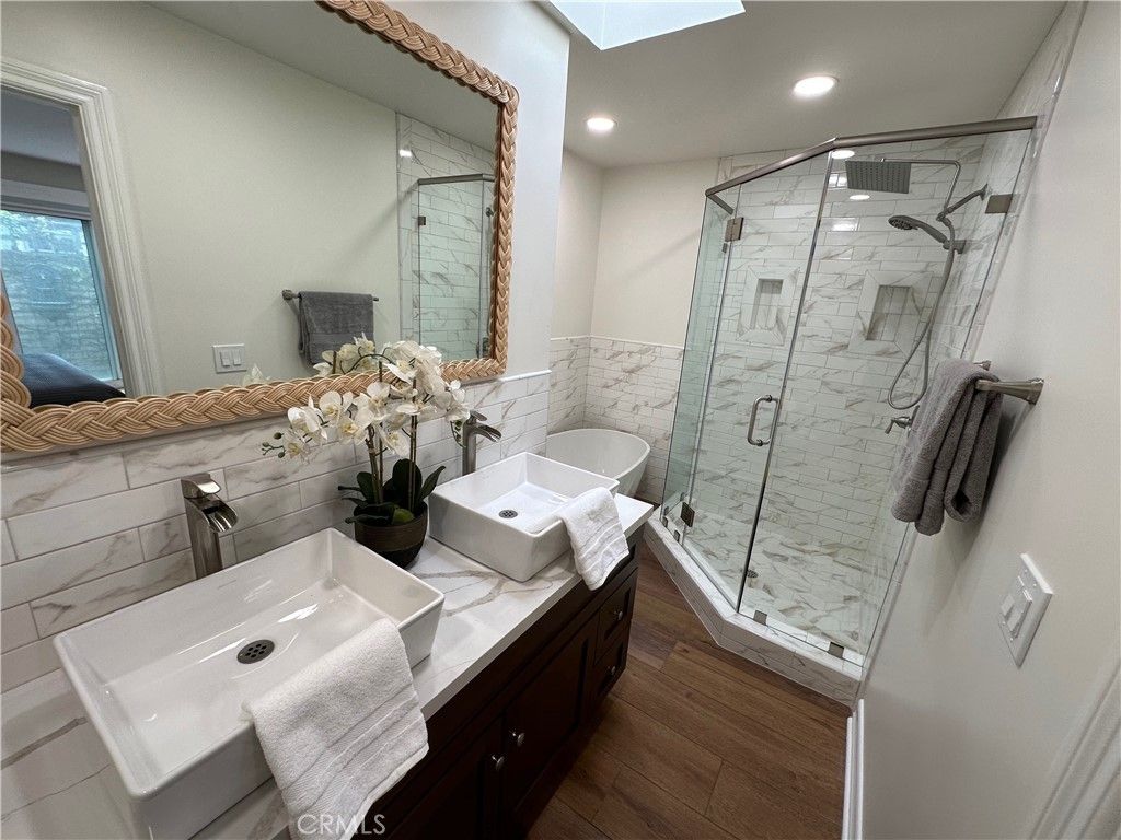 Bathroom, Dual Sink Vanities, Glass Shower, Interior, Marble Walls, Recessed Lighting, Wood Texture Flooring