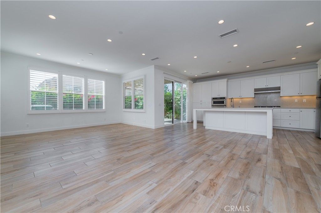 Empty room, Interior, Kitchen, Recessed Lighting, Stainless Steel Appliances, Wood Texture Flooring
