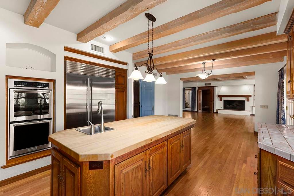 Fireplace, Interior, Kitchen, Pendant Lights, Stainless Steel Appliances, Tile Countertops, Wooden Beams, Wood Texture Flooring