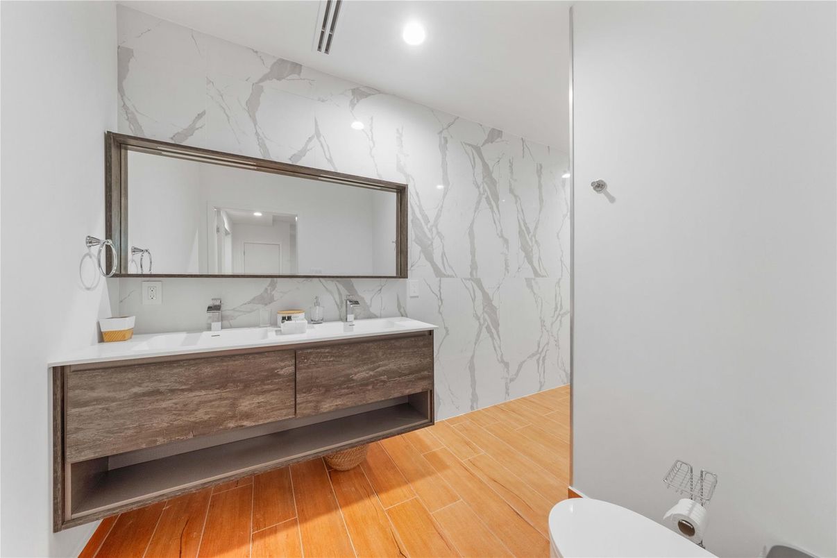 Bathroom, Dual Sink Vanities, Interior, Marble Walls, Recessed Lighting, Wood Texture Flooring