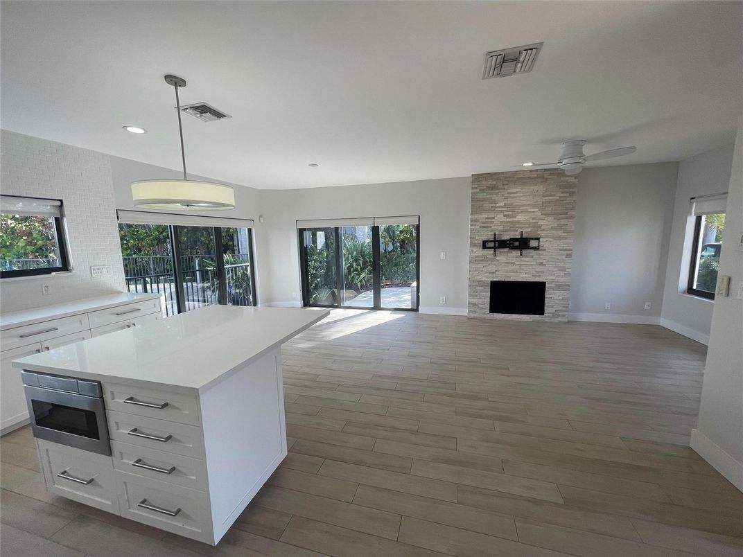 Empty room, Fireplace, Interior, Kitchen, Pendant Lights, Recessed Lighting, Stone Walls, Wood Texture Flooring