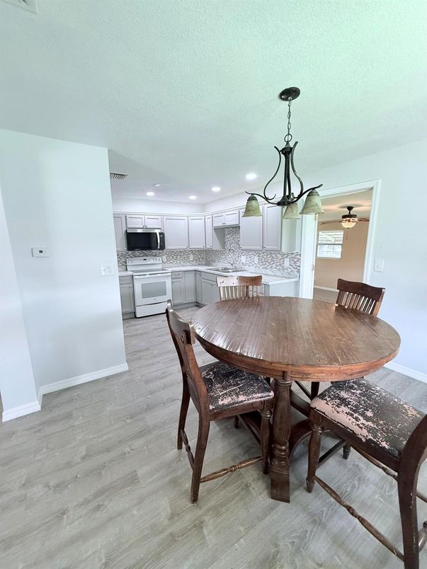 Chandelier, Dining room, Interior, Kitchen, Pendant Lights, Recessed Lighting, Stainless Steel Appliances, Wood Texture Flooring