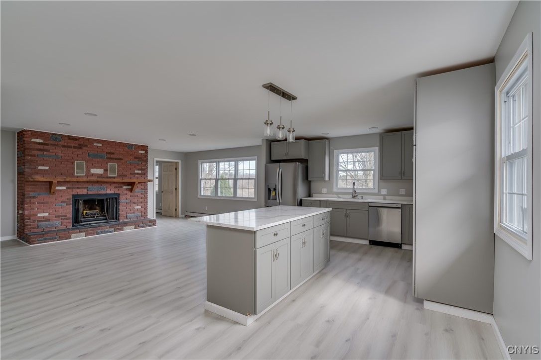 Fireplace, Interior, Kitchen, Pendant Lights, Recessed Lighting, Stainless Steel Appliances, Stone Walls, Wood Texture Flooring