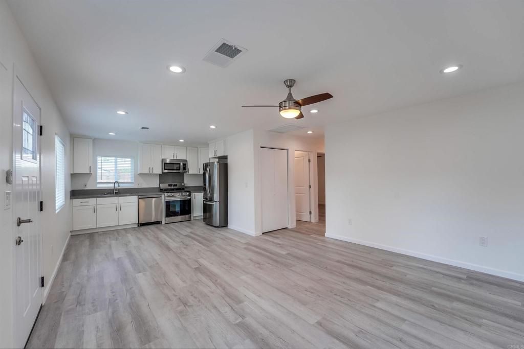 Empty room, Interior, Kitchen, Recessed Lighting, Stainless Steel Appliances, Wood Texture Flooring