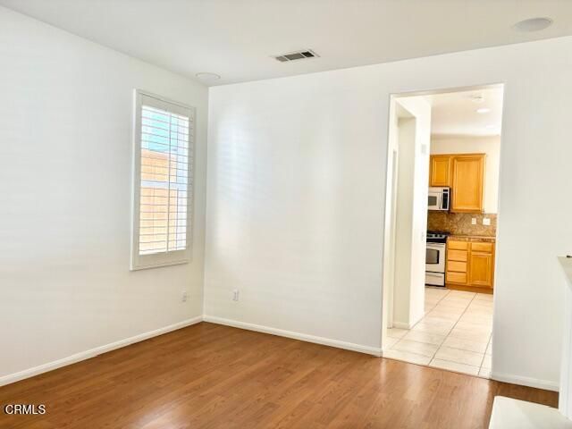 Empty room, Interior, Kitchen, Recessed Lighting, Stainless Steel Appliances, Wood Texture Flooring