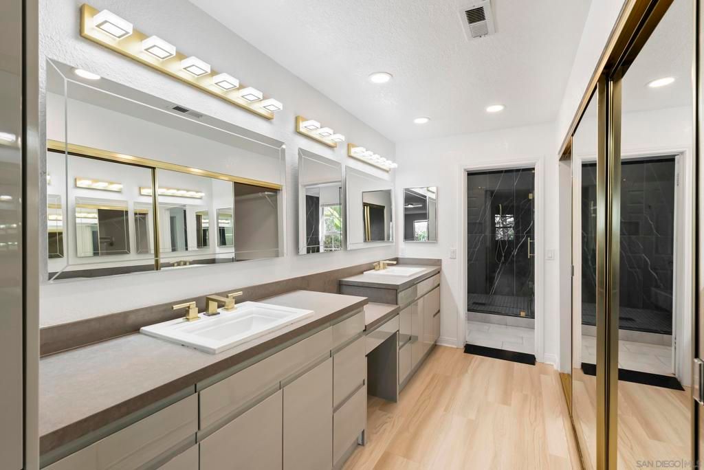 Bathroom, Dual Sink Vanities, Glass Shower, Interior, Marble Walls, Recessed Lighting, Wood Texture Flooring