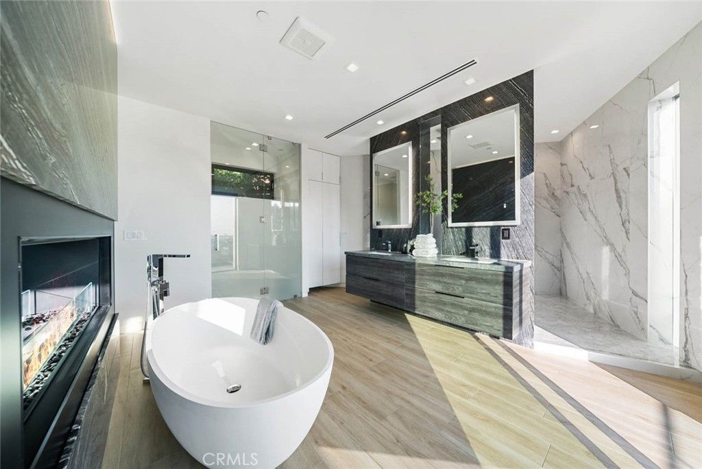 Bathroom, Dual Sink Vanities, Free Standing Baths, Glass Shower, Interior, Marble Walls, Recessed Lighting, Wood Texture Flooring