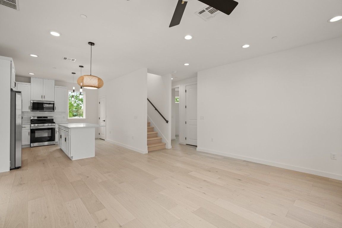 Empty room, Interior, Kitchen, Pendant Lights, Recessed Lighting, Stainless Steel Appliances, Wood Texture Flooring