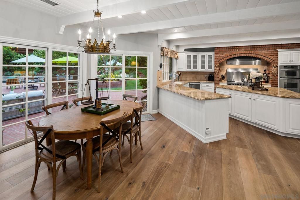 Chandelier, Dining room, Interior, Kitchen, Recessed Lighting, Stainless Steel Appliances, Stone Walls, Wood Texture Flooring