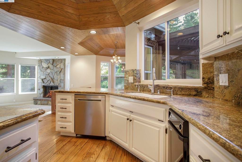 Chandelier, Fireplace, Interior, Kitchen, Recessed Lighting, Stainless Steel Appliances, Stone Walls, Wooden Ceilings, Wood Texture Flooring