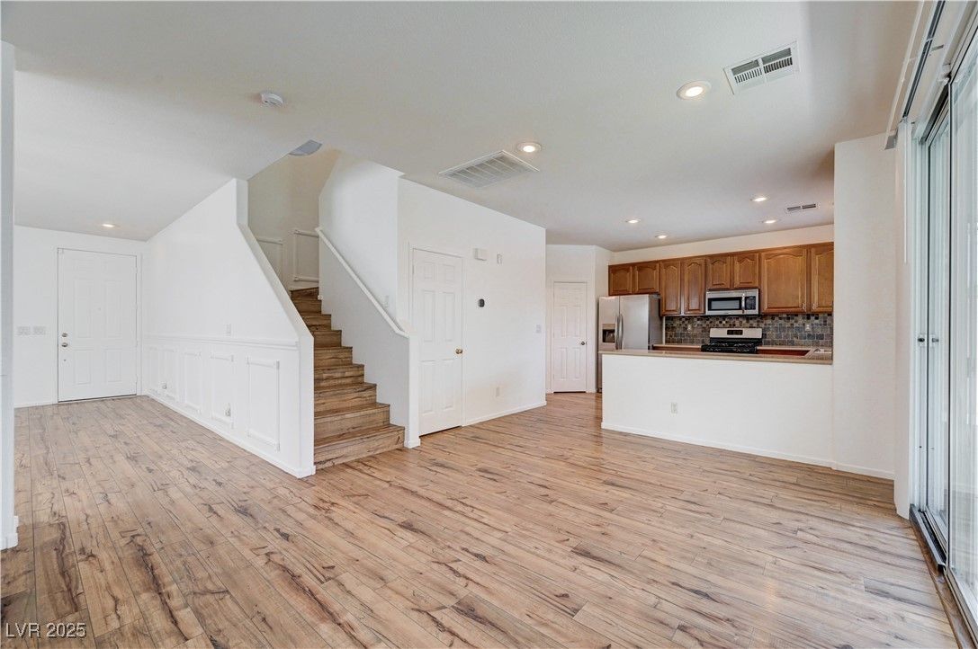 Empty room, Interior, Kitchen, Recessed Lighting, Stainless Steel Appliances, Wood Texture Flooring